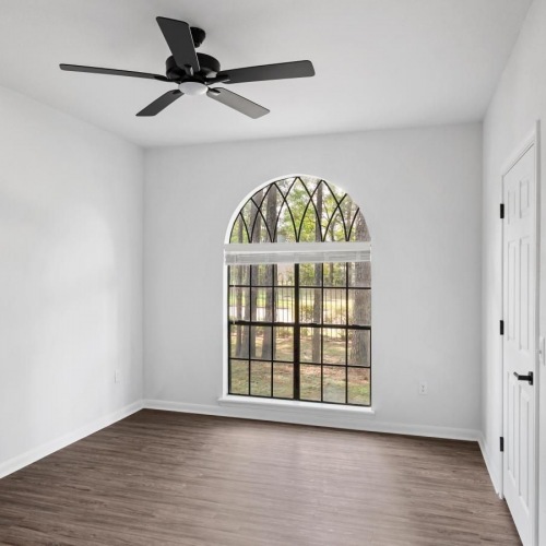 Settle into comfort at Paramount at Kingwood a room with a wood floor and a ceiling fan